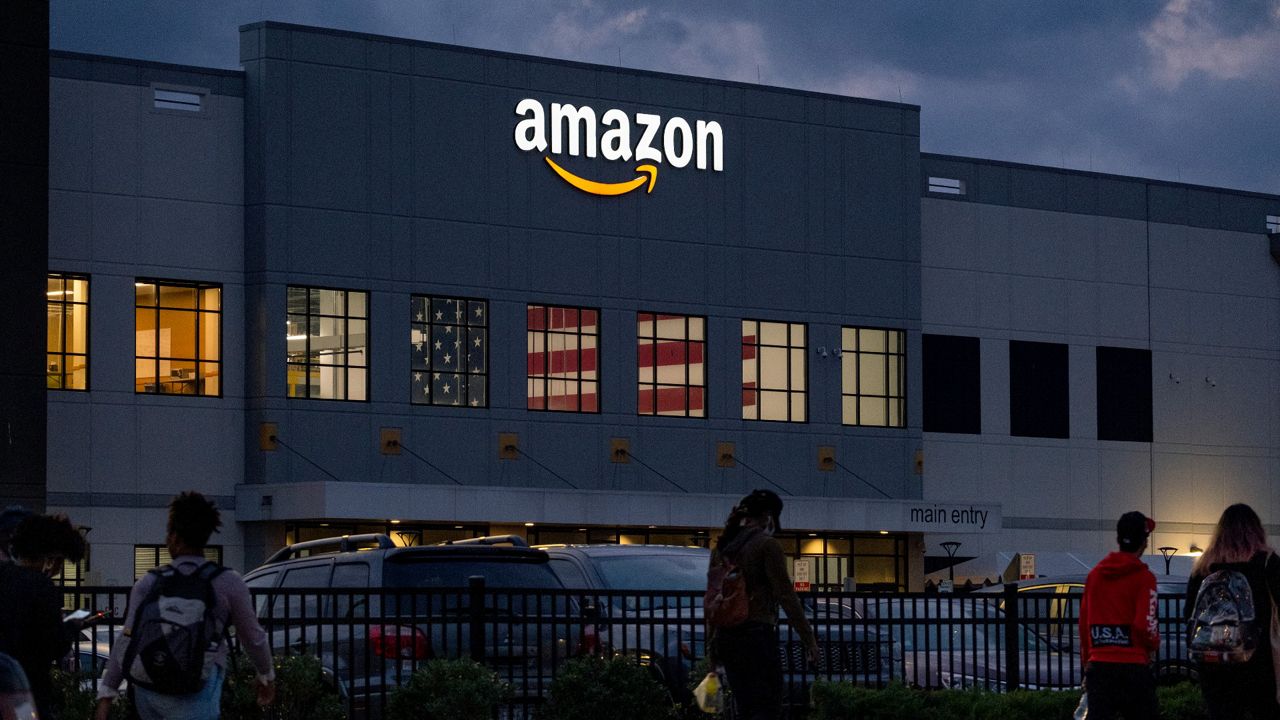 People arrive for work at the Amazon distribution center on Staten Island, on Oct. 25, 2021. A federal judge has ordered Amazon to stop retaliating against employees engaged in workplace activism, issuing a mixed ruling Friday, Nov. 18, 2022, that also hands a loss to the federal labor agency that sued the company earlier this year. (AP Photo/Craig Ruttle, File)