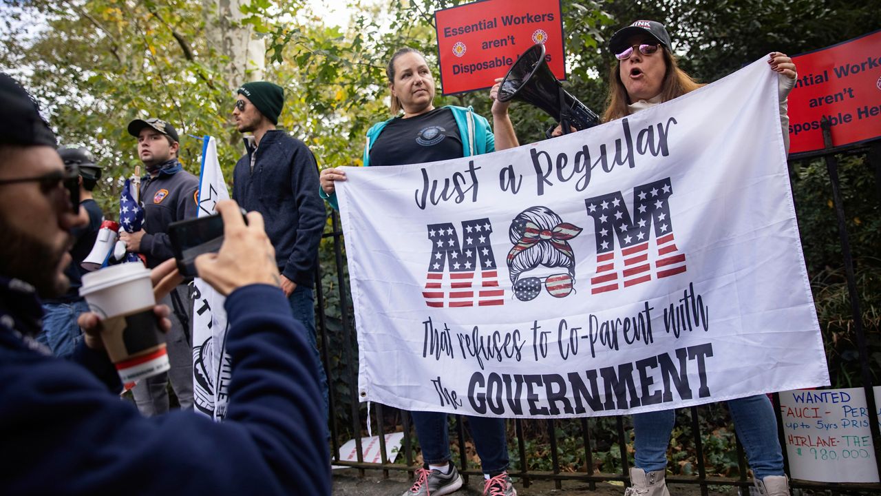 New York City municipal workers protest outside the Gracie Mansion Conservancy against the coming COVID-19 vaccine mandate for city workers, Thursday, Oct. 28, 2021, in New York.(AP Photo/Jeenah Moon)