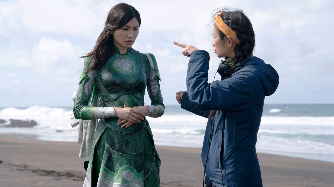 This image released by Marvel Studios shows Gemma Chan, left, and director Chloé Zhao on the set of "Eternals." (Marvel Studios via AP)