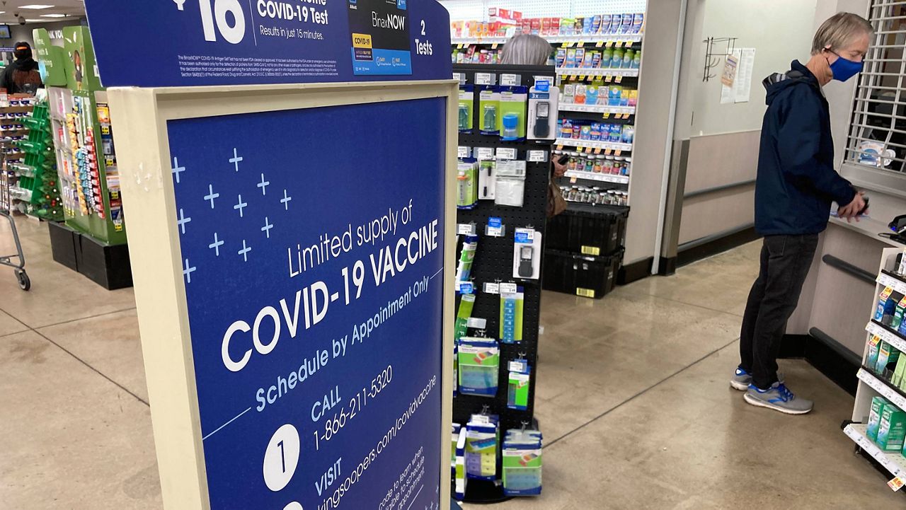 A man checks in for a COVID-19 booster shot at a pharmacy in a grocery store in downtown Denver on Nov. 3. (AP Photo/David Zalubowski)