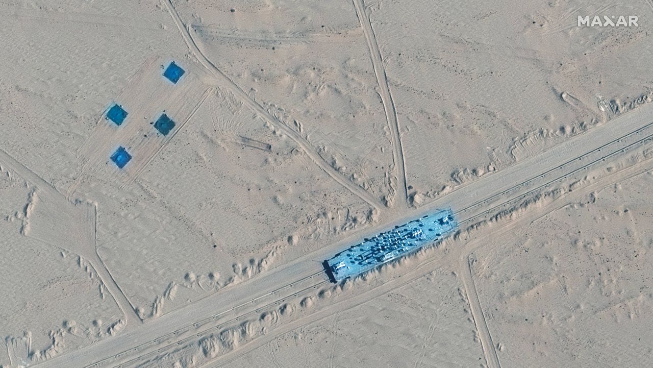 Satellite images appear to show China has built mock-ups of U.S. Navy aircraft carriers and destroyers in its northwestern desert, such as the one at center in this image. (Maxar Technologies via AP) 