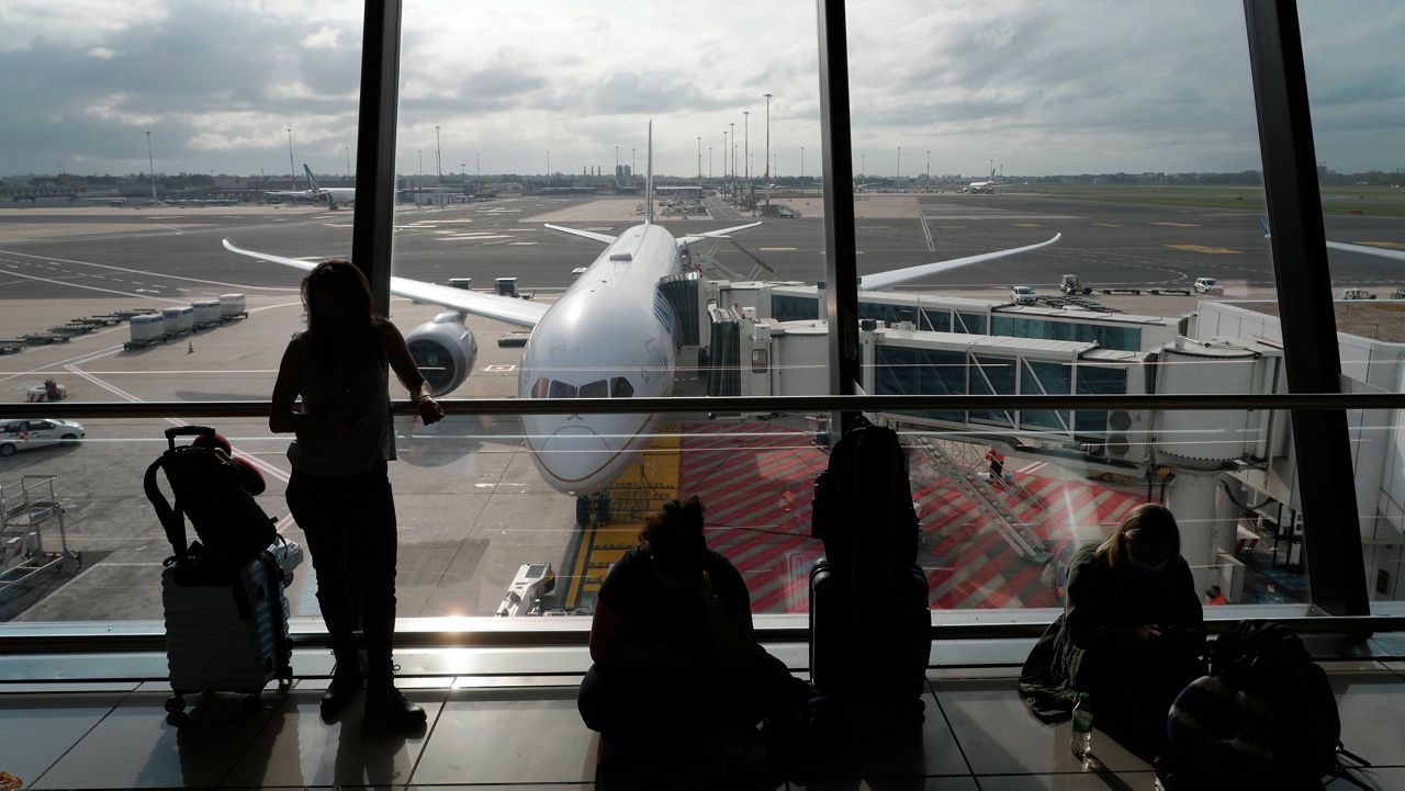 Passengers wait to board a United Airlines flight, seen in the background, for Newark, N.J., at Fiumicino's Leonardo Da Vinci airport, near Rome, on Monday. (AP Photo/Alessandra Tarantino)