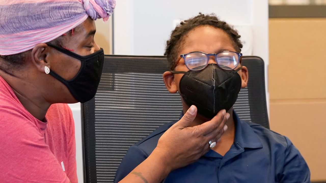 Latosha Wilson, left, comforts her son Kerington Wilson, 9, after he received the Pfizer-BioNTech COVID-19 vaccine for children 5 to 12 years old at a vaccination site in Fort Worth, Texas, Thursday, Nov. 11, 2021. (AP Photo/LM Otero)