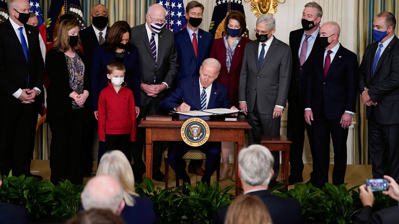 President Joe Biden signs the "Confidentiality Opportunities for Peer Support Counseling Act or the COPS Counseling Act," in the State Dining Room of the White House, Thursday, Nov. 18, 2021, in Washington. (AP Photo/Evan Vucci)