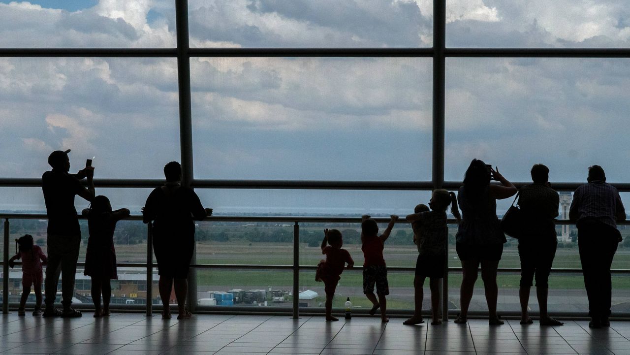 Families watch planes on the tarmac at O.R. Tambo International Airport in Johannesburg on Nov. 29. (AP Photo/Jerome Delay)