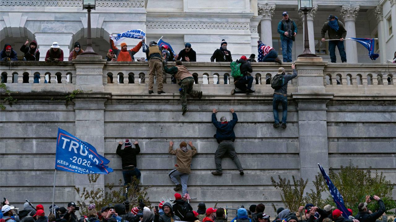 Supporters of President Donald Trump climb the west wall of the the U.S. Capitol in Washington as they try to storm the building on Jan. 6, 2021. (AP Photo/Jose Luis Magana)