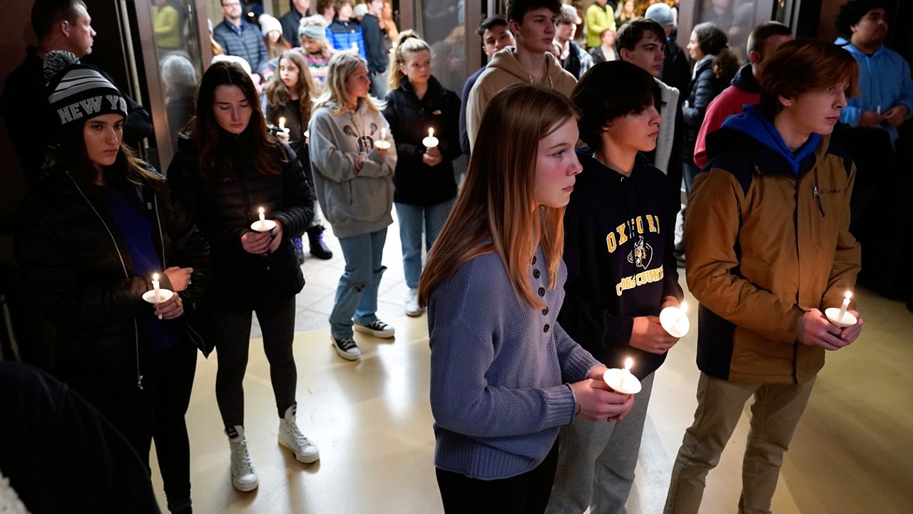 Students attend a vigil at LakePoint Community Church in Oxford, Mich., Tuesday, Nov. 30, 2021. Authorities say a 15-year-old sophomore opened fire at Oxford High School, killing several students and wounding multiple other people, including a teacher. (AP Photo/Paul Sancya)