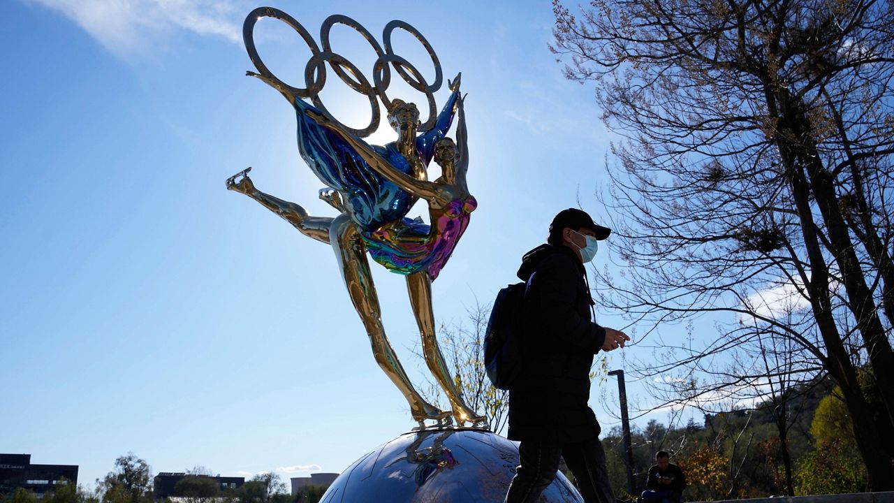 A visitor to Shougang Park in Beijing walks past a sculpture for the Winter Olympics on Nov. 9. (AP Photo/Ng Han Guan)