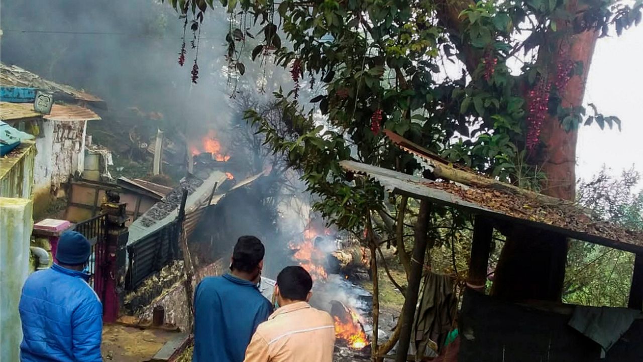 People try to contain the fire after an army helicopter carrying India's Chief of Defense Staff Gen. Bipin Rawat crashed Wefnesday near Coonoor, India. (Bangalore New Photos via AP)