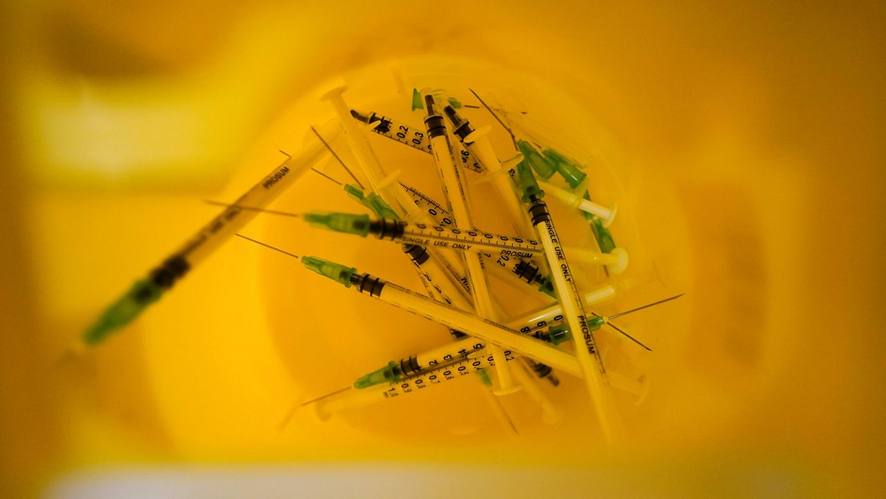 Used syringes are seen in a bin at a vaccination center in London on Dec. 4. (AP Photo/Alberto Pezzali, File)