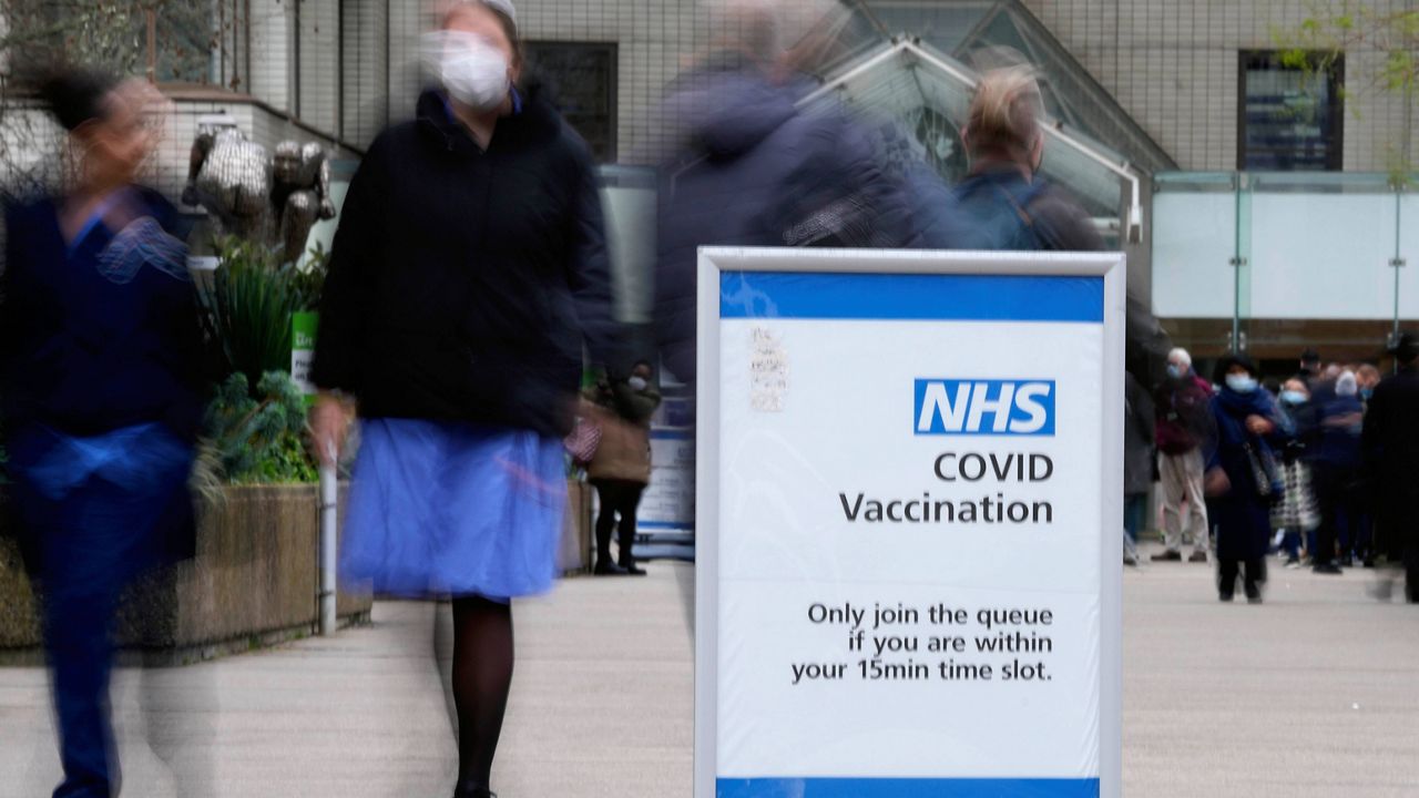 A sign marks the entrance of a vaccination centre at St Thomas' Hospital in London, Wednesday, Dec. 15, 2021. As of Monday in England, people were urged to work from home if possible, with long lines forming at vaccination centers for people to get booster shots to protect themselves against the coronavirus omicron variant. (AP Photo/Frank Augstein)