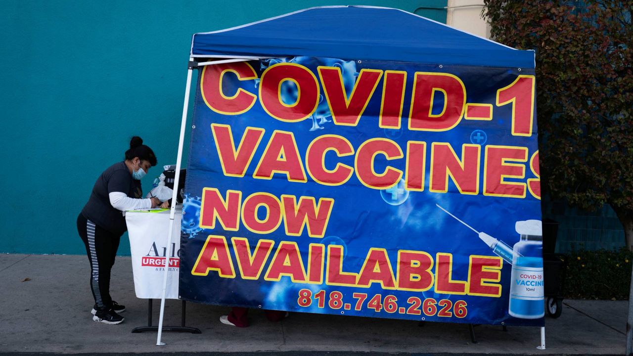 Josefina Vasquez fills out a form to take a COVID-19 test at a pop-up testing and vaccination site outside a swap meet in Los Angeles, Wednesday, Dec. 15, 2021. (AP Photo/Jae C. Hong)