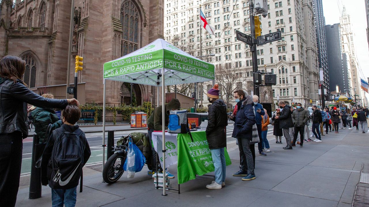 People line up for PCR and rapid antigen COVID-19 coronavirus tests on Wall Street in the Financial District in New York on Thursday. (AP Photo/Ted Shaffrey)