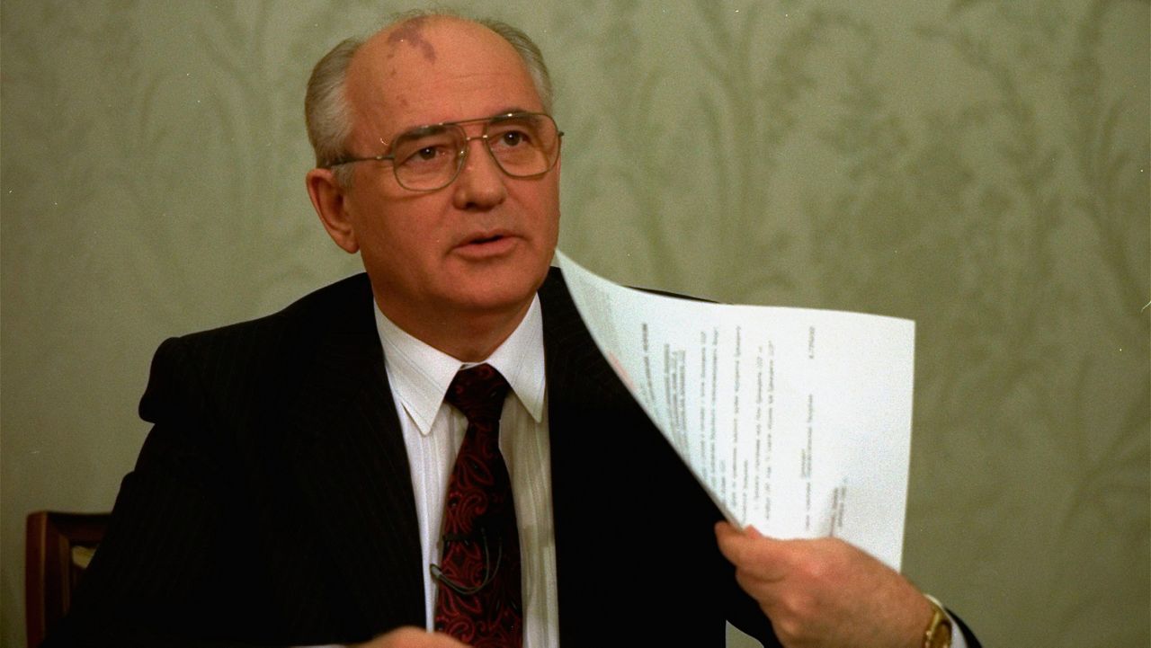 FILE - Mikhail Gorbachev flashes the decree relinquishing control of nuclear weapons to Russian President Boris Yeltsin after its signature at the Kremlin in Moscow on Dec. 25, 1991. (AP Photo/Liu Heung Shing, File)