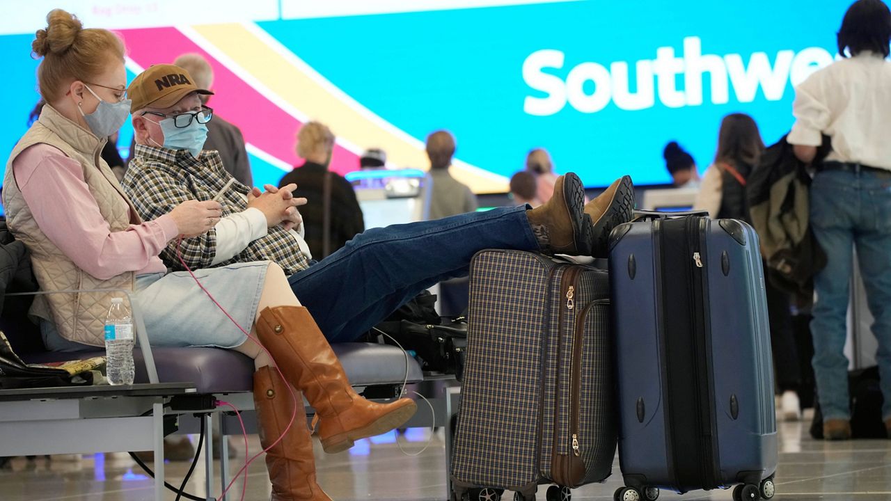 Travelers wait at the check-in counter for Southwest Airlines at Denver International Airport on Friday. (AP Photo/David Zalubowski)