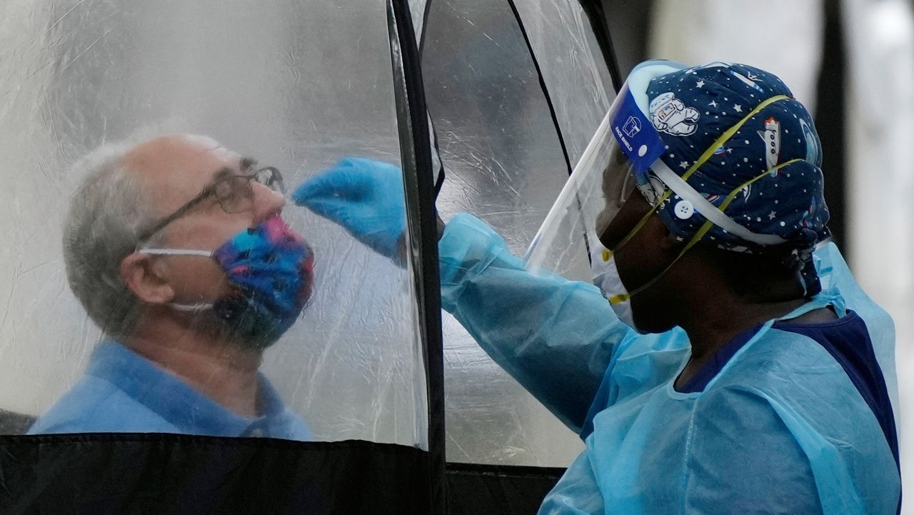 A man is tested for COVID-19, at a walk-up testing site run by Nomi Health, Tuesday, Dec. 28, 2021, in downtown Miami. (AP Photo/Rebecca Blackwell)