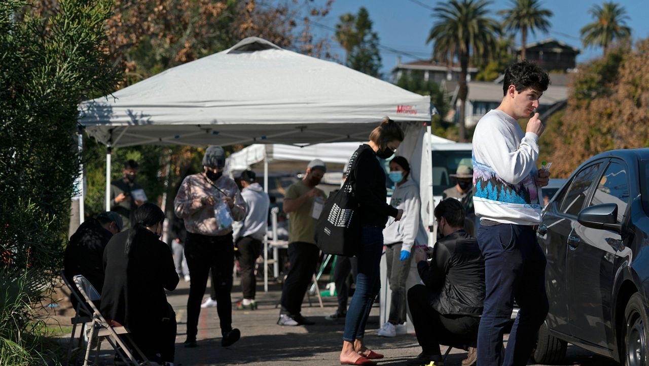 People take a COVID-19 test in Los Angeles, Jan. 4, 2022. (AP Photo/Jae C. Hong)