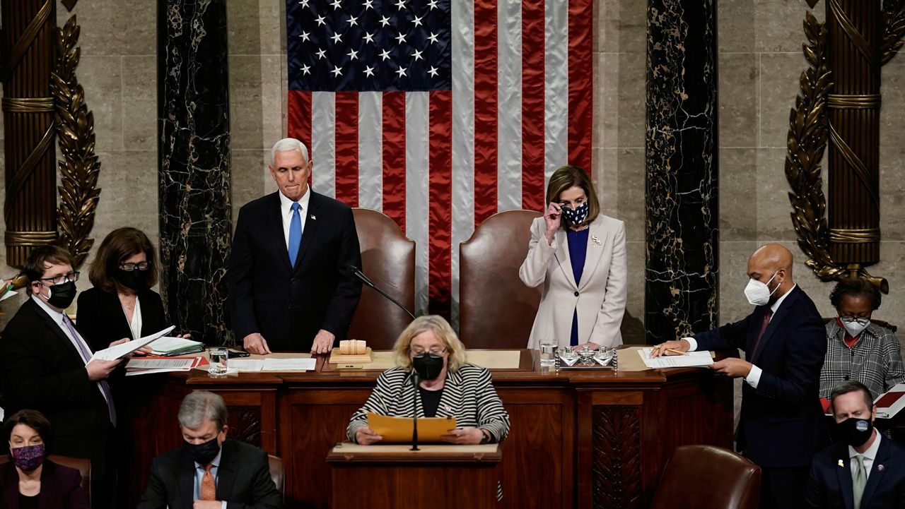 Vice President Mike Pence and Speaker of the House Nancy Pelosi, D-Calif., read the final certification of Electoral College votes cast in November's presidential election during a joint session of Congress after working through the night, at the Capitol in Washington, Jan. 7, 2021. (AP Photo/J. Scott Applewhite, Pool)