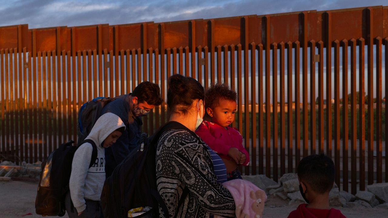 FILE - A pair of migrant families from Brazil wait to be processed by U.S. Border Patrol agents after passing through a gap in the border wall from Mexico in Yuma, Ariz., Thursday, June 10, 2021, to seek asylum. (AP Photo/Eugene Garcia, File)