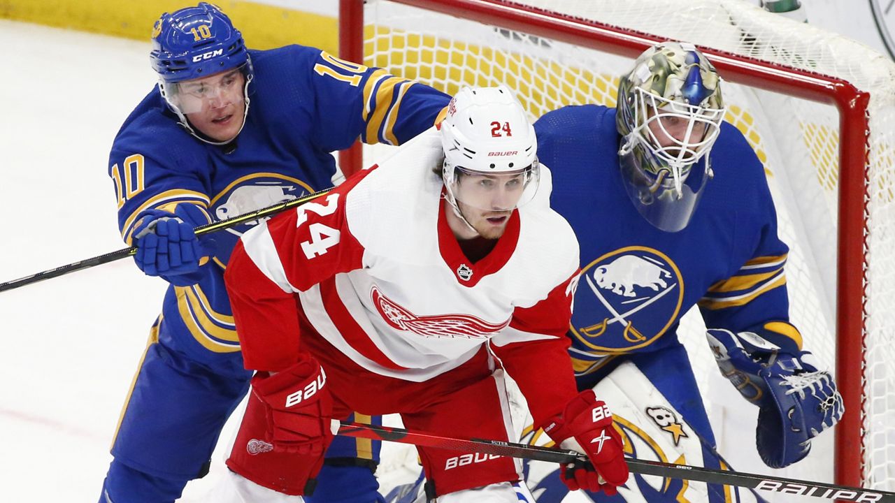 Buffalo Sabres defenseman Henri Jokiharju (10) and Detroit Red Wings center Pius Suter (24) battle for position in front of Buffalo Sabres goaltender Aaron Dell (80) during the second period of an NHL hockey game, Monday, Jan. 17, 2022, in Buffalo, N.Y. (AP Photo/Jeffrey T. Barnes)