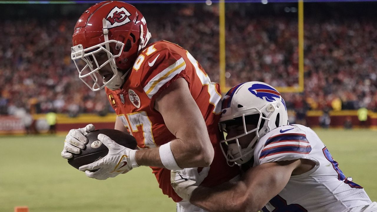 Kansas City Chiefs tight end Travis Kelce (87) catches an 8-yard touchdown pass over Buffalo Bills outside linebacker Matt Milano (58) during overtime in an NFL divisional round playoff football game, Sunday, Jan. 23, 2022, in Kansas City, Mo. The Chiefs won 42-36. (AP Photo/Charlie Riedel)