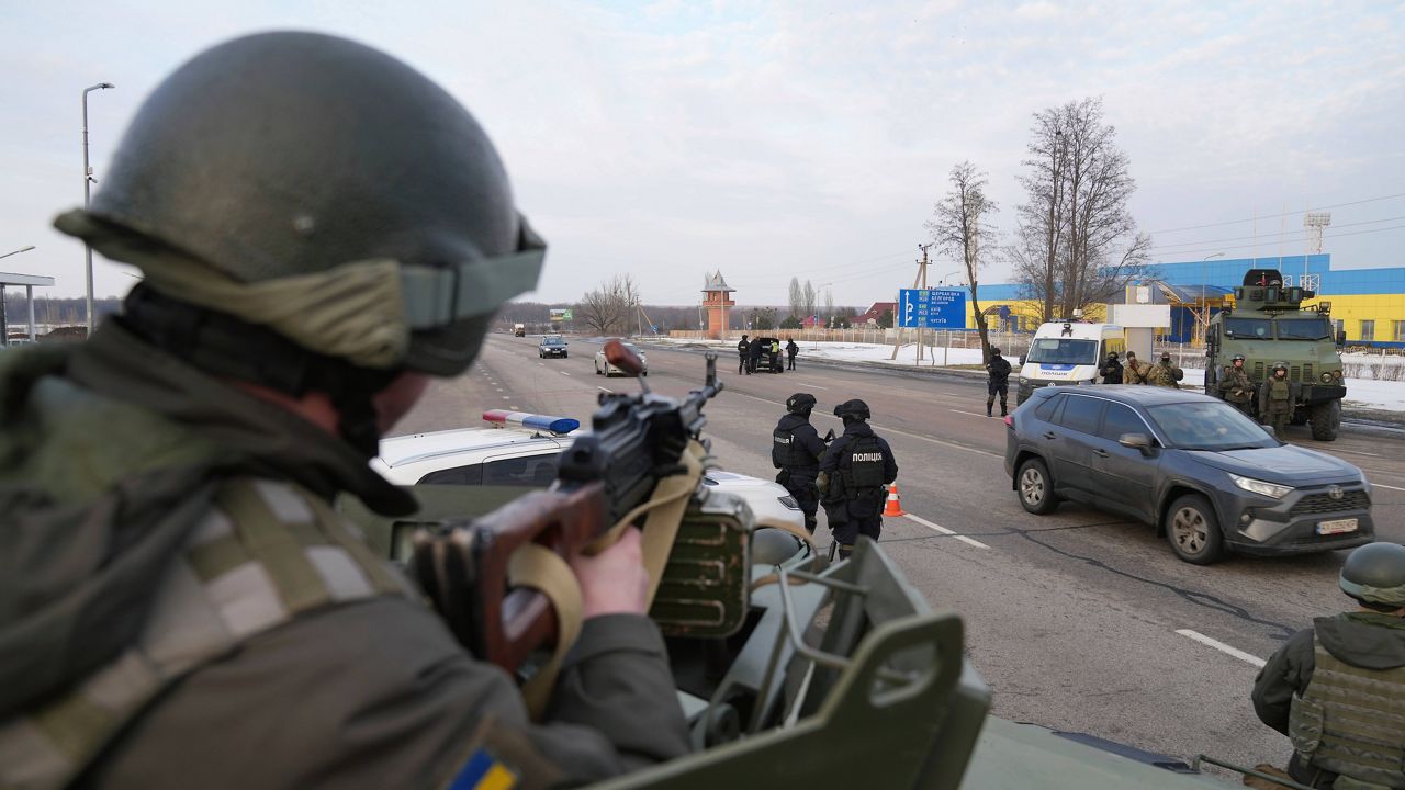 A Ukrainian National guard soldier, left, holds his weapon ready Thursday as he guards the mobile checkpoint with Ukrainian Security Service agents and police officers in Kharkiv, Ukraine. (AP Photo/Evgeniy Maloletka)