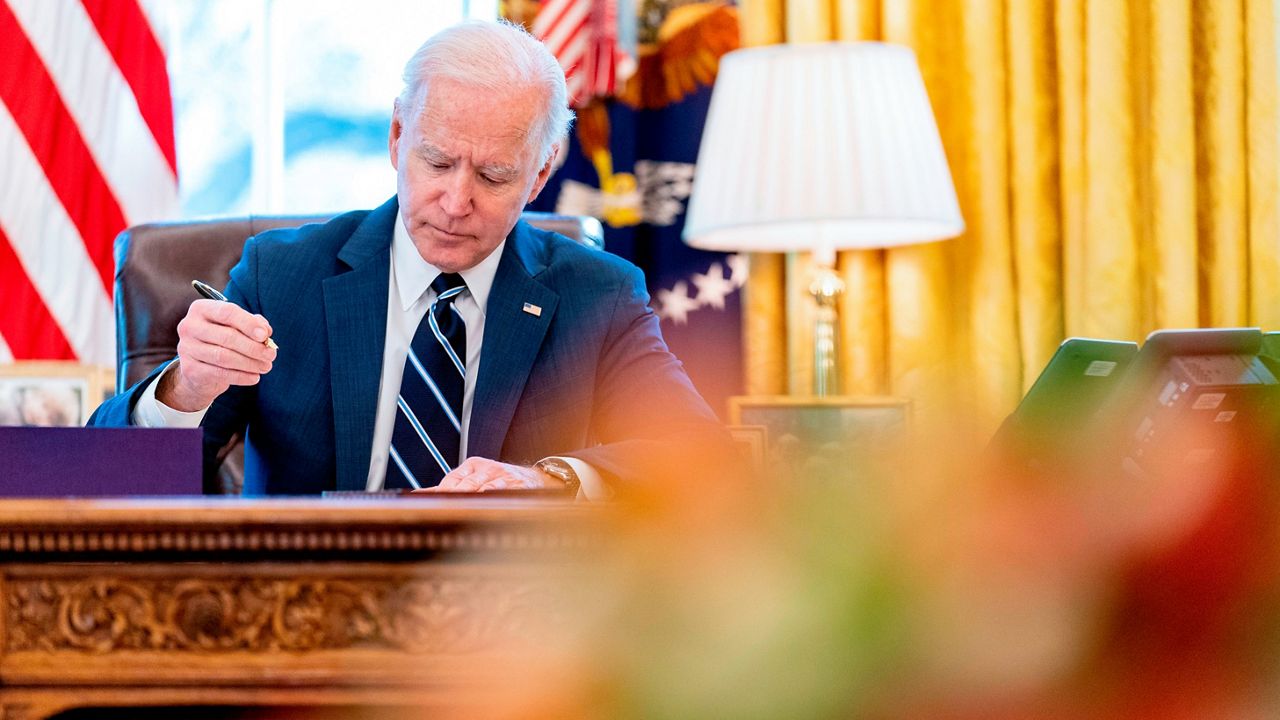 FILE - President Joe Biden signs the American Rescue Plan, a coronavirus relief package, in the Oval Office of the White House, March 11, 2021, in Washington. (AP Photo/Andrew Harnik, File)