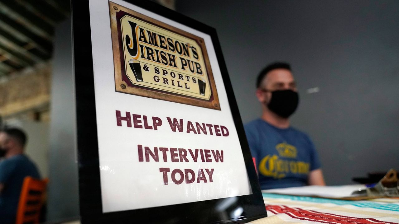 A hiring sign is shown at a booth for Jameson's Irish Pub during a job fair on Sept. 22, 2021, in the West Hollywood section of Los Angeles. (AP Photo/Marcio Jose Sanchez, File)