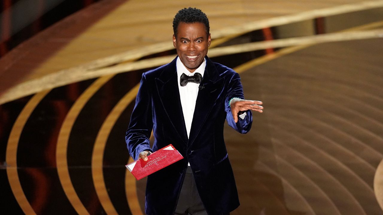 Chris Rock presents the award for best documentary feature at the Oscars on Sunday, March 27, 2022, at the Dolby Theatre in Los Angeles. (AP Photo/Chris Pizzello)