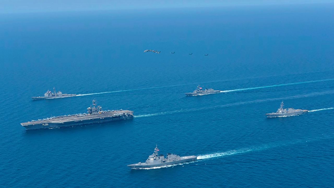 This photo provided by Japan Maritime Self-Defense Force shows USS Abraham Lincoln, left, and JS Kongo, front, sail in formation during a U.S.-Japan bilateral exercise at the Sea of Japan on April 12, 2022. (Japan Maritime Self-Defense Force via AP)