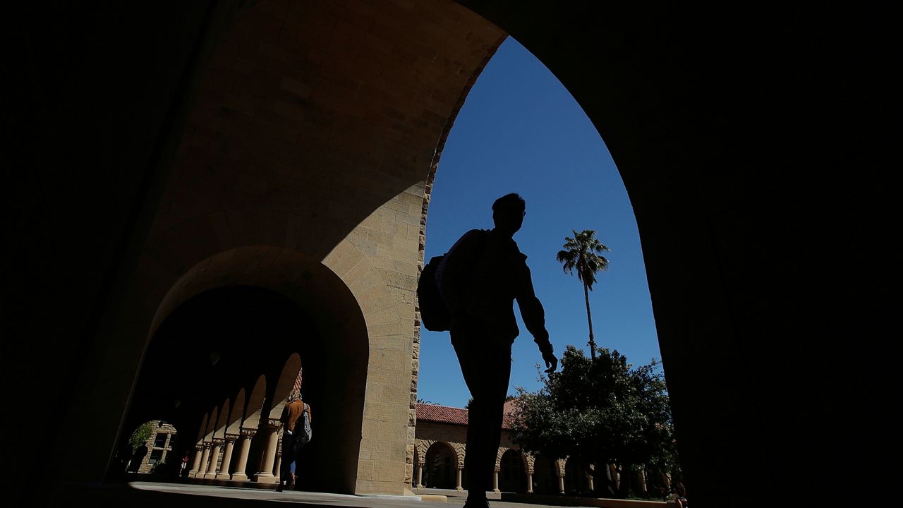 FILE - People walk on the campus at Stanford University in Stanford, Calif. (AP Photo/Jeff Chiu, File)