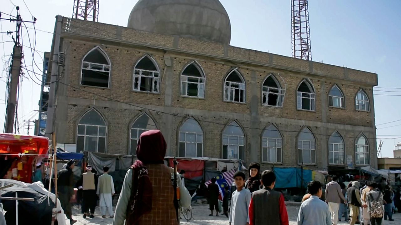 FILE - This frame grab image from video, shows a Taliban fighter standing guard outside the site of a bomb explosion inside a mosque, in Mazar-e-Sharif province, Afghanistan, Thursday, April 21, 2022. (AP Photo, File)