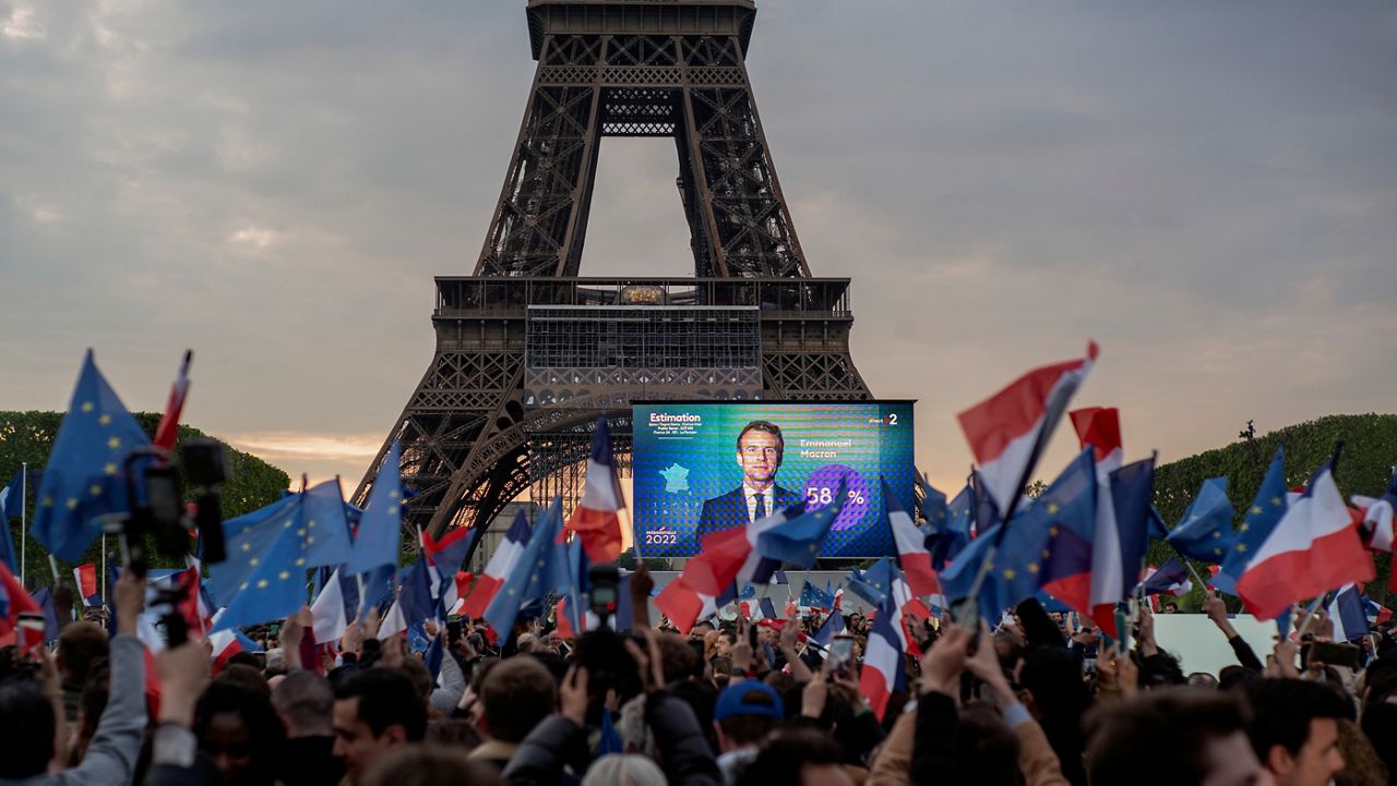 French President Emmanuel Macron celebrates with supporters in front of the Eiffel Tower Paris, France, Sunday, April 24, 2022. (AP Photo/Rafael Yaghobzadeh)