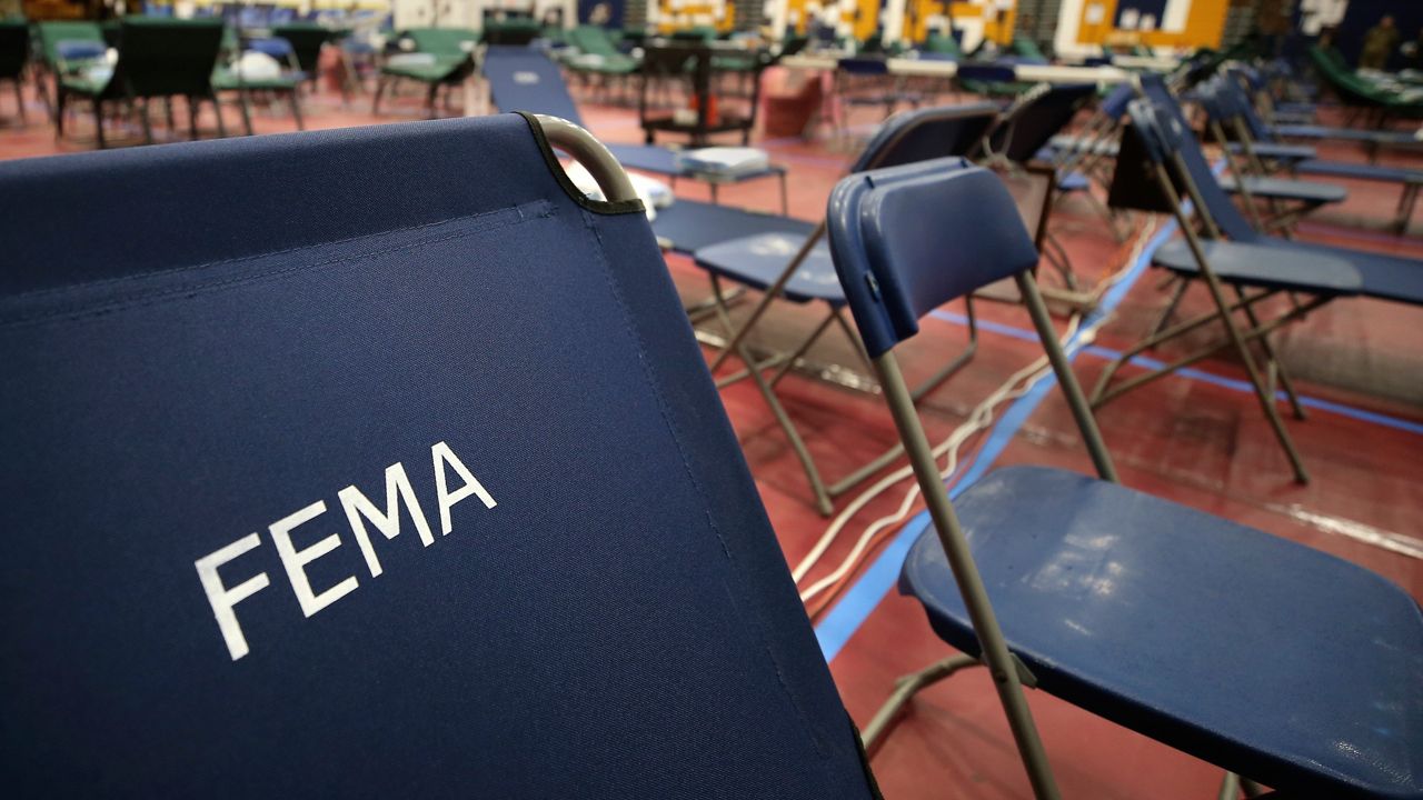 FILE - A portable cot, with the Federal Emergency Management Agency logo FEMA printed on the backrest, and other cots line the basketball court at a makeshift medical facility in a gymnasium at Southern New Hampshire University in Manchester, N.H., March 24, 2020. (AP Photo/Charles Krupa, File)