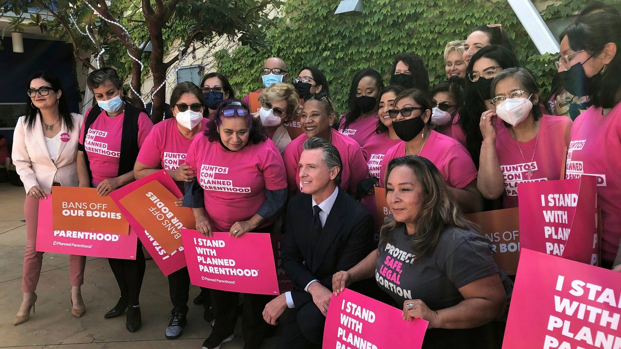 California Gov. Gavin Newsom poses with workers and volunteers on Wednesday, May 4, 2022, at a Planned Parenthood office near downtown Los Angeles. (AP Photo/Michael R. Blood)