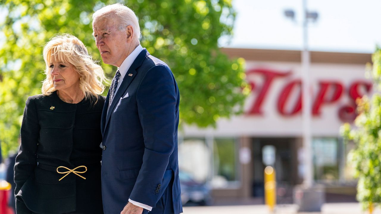 President Joe Biden and first lady Jill Biden pay their respects to the victims of Saturday's shooting at a memorial across the street from the TOPS Market, at right, in Buffalo, N.Y., Tuesday, May 17, 2022. (AP Photo/Andrew Harnik)