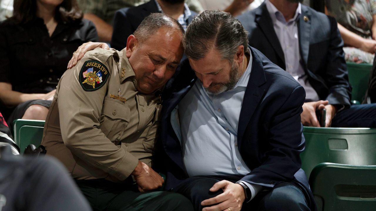 Sen. Ted Cruz, R-Texas, right, and Uvalde County Sheriff Ruben Nolasco pray during a prayer vigil in Uvalde, Texas, Wednesday, May 25, 2022. The vigil was held to honor the victims killed in Tuesday's shooting at Robb Elementary School. (AP Photo/Jae C. Hong)