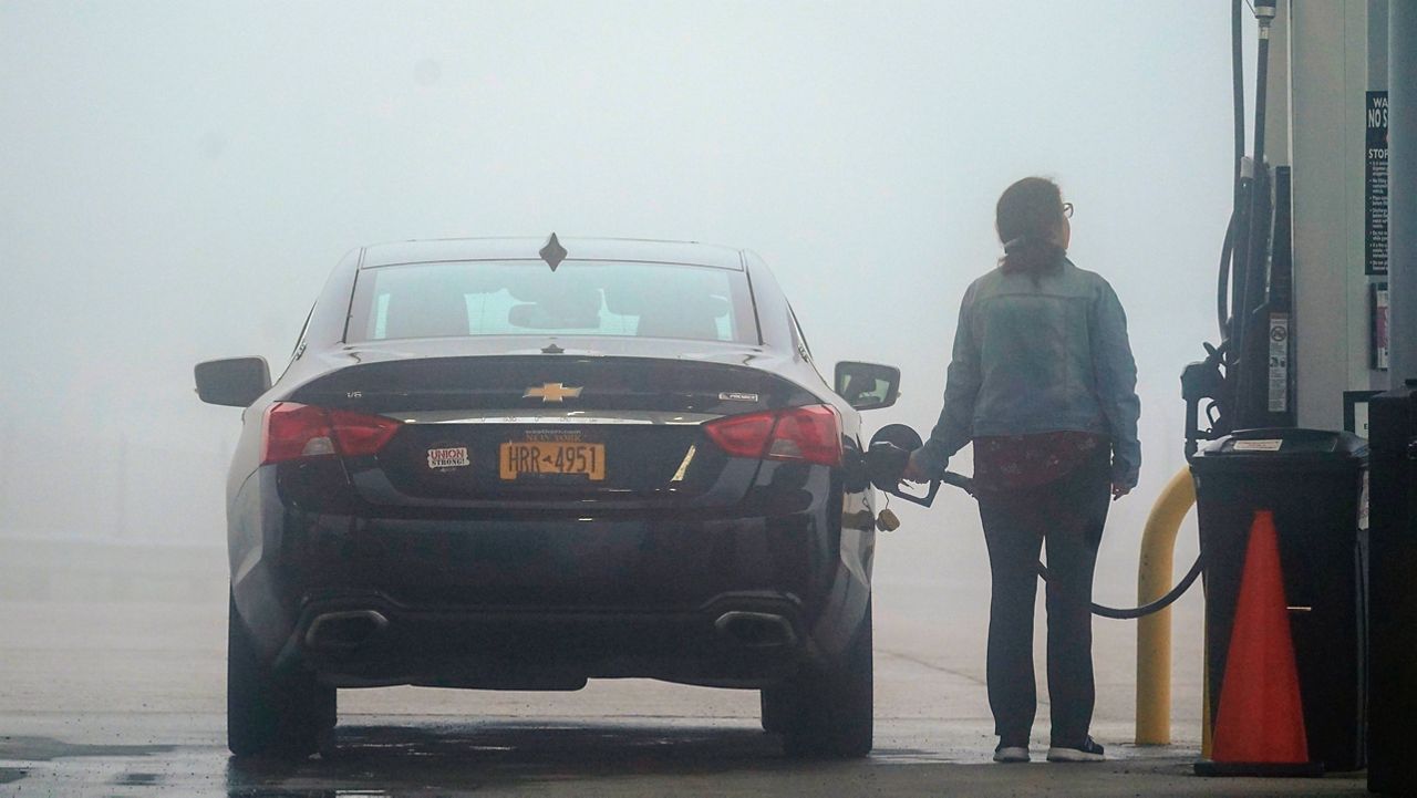 A motorist fills up the tank of a car Friday ahead of the Memorial Day holiday weekend, on a foggy morning at the Hickory Run Service Plaza in Jim Thorpe, Pa.. (AP Photo/Matt Rourke)