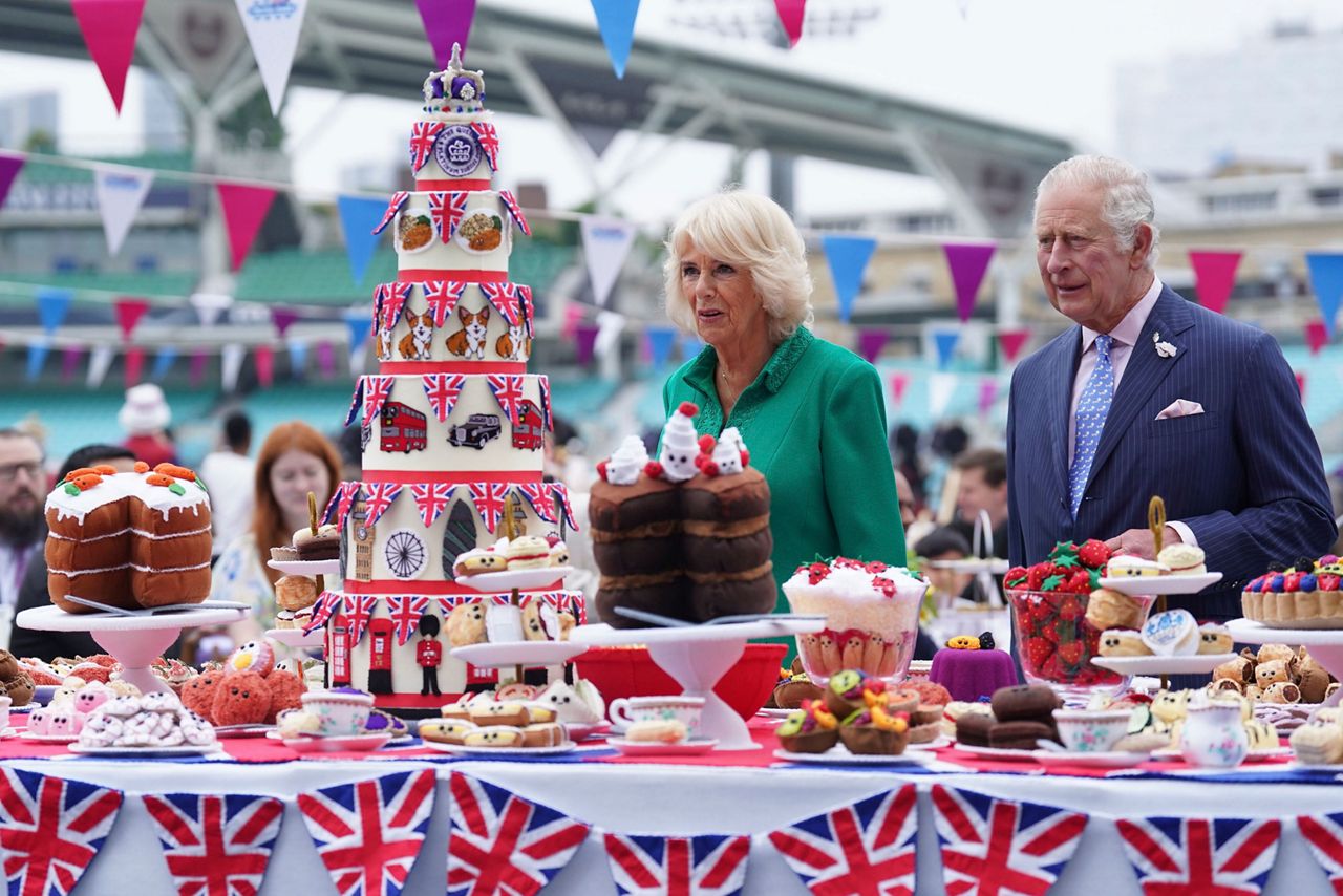 Britain's Prince Charles, right and Camilla, Duchess of Cornwall, as Patron of the Big Lunch, arrive for the Big Jubilee Lunch with tables set up on the pitch at The Oval cricket ground, on the last of four days of celebrations to mark Queen Elizabeth II's Platinum Jubilee, in London, Sunday, June 5, 2022. (Stefan Rousseau/PA via AP)