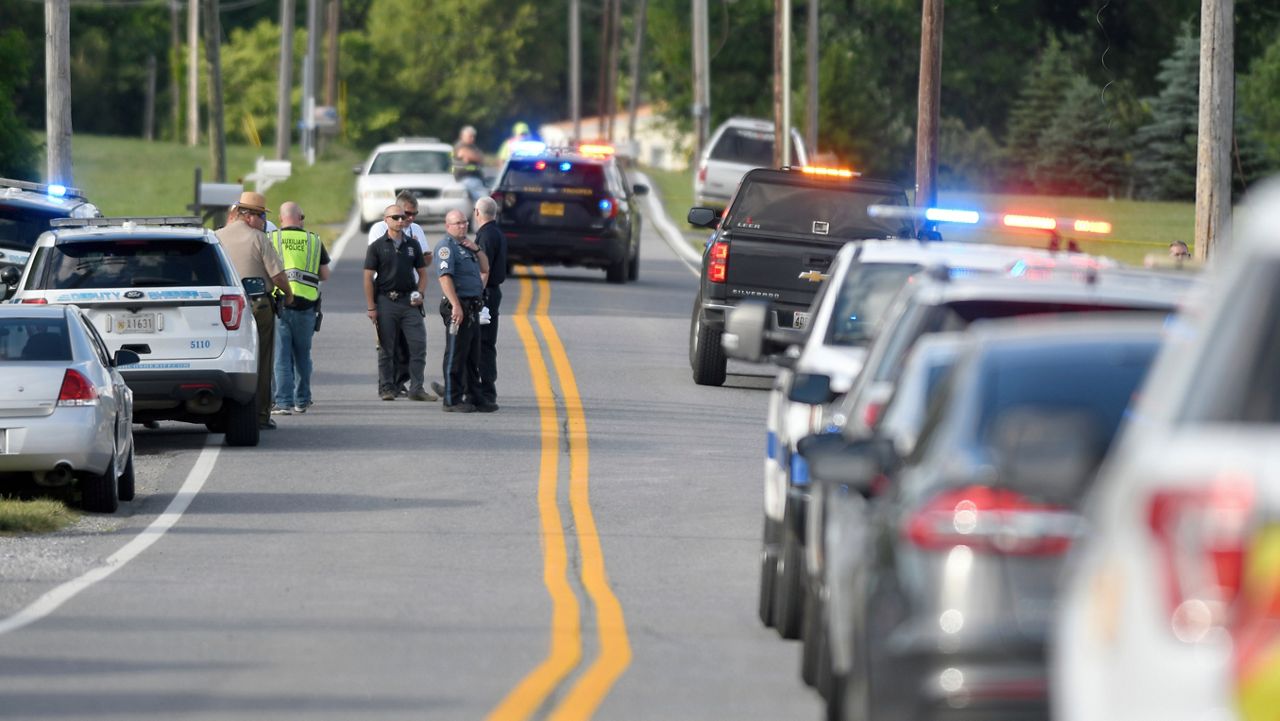 Police work near where a man opened fire at a business, killing three people before the suspect and a state trooper were wounded in a shootout, according to authorities, in Smithsburg, Md., Thursday, June 9, 2022. (AP Photo/Steve Ruark)