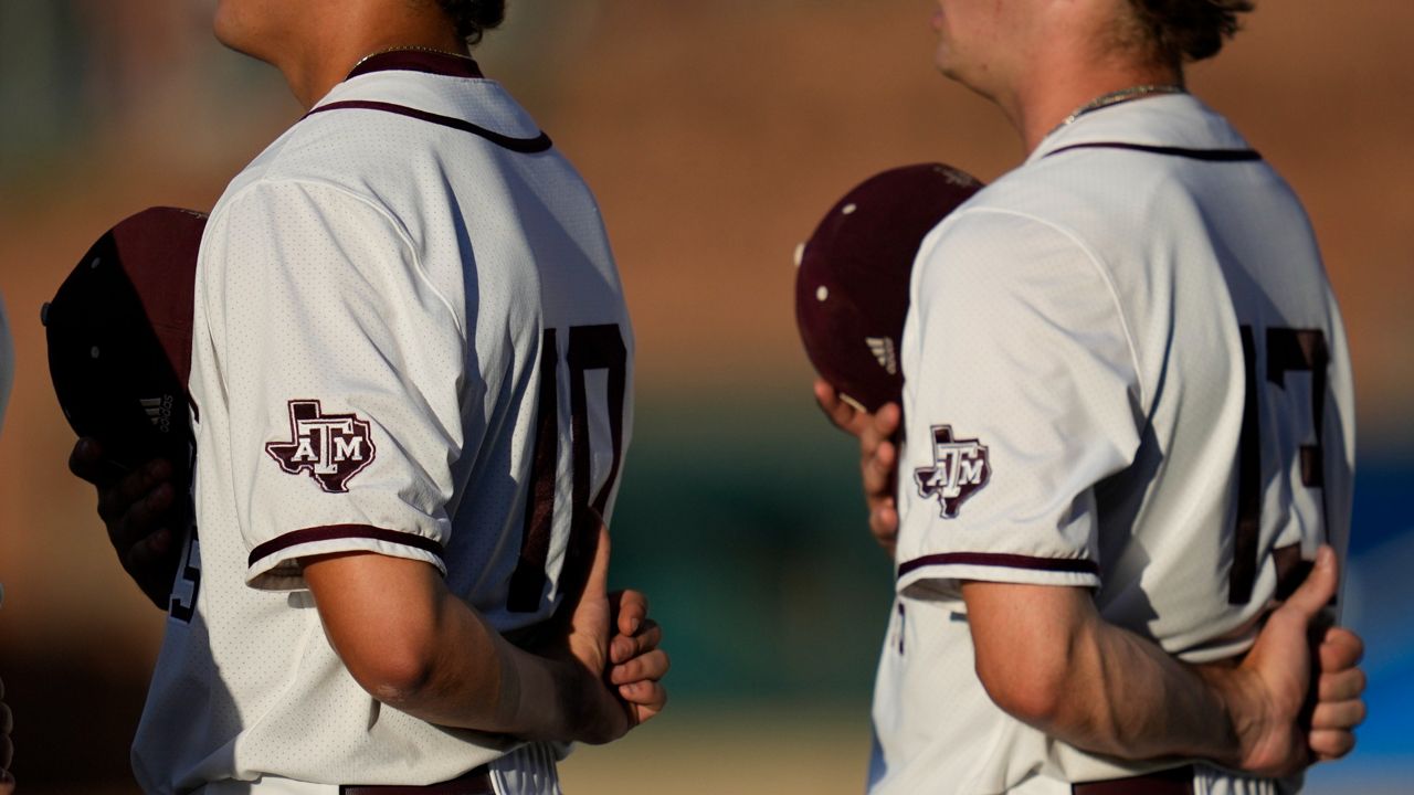 Texas A&M's Chris Cortez, left, and Robert Hogan,right, stand for the national anthem before the start of an NCAA college baseball super regional tournament game against Louisville Friday, June 10, 2022, in College Station, Texas. (AP Photo/Sam Craft)