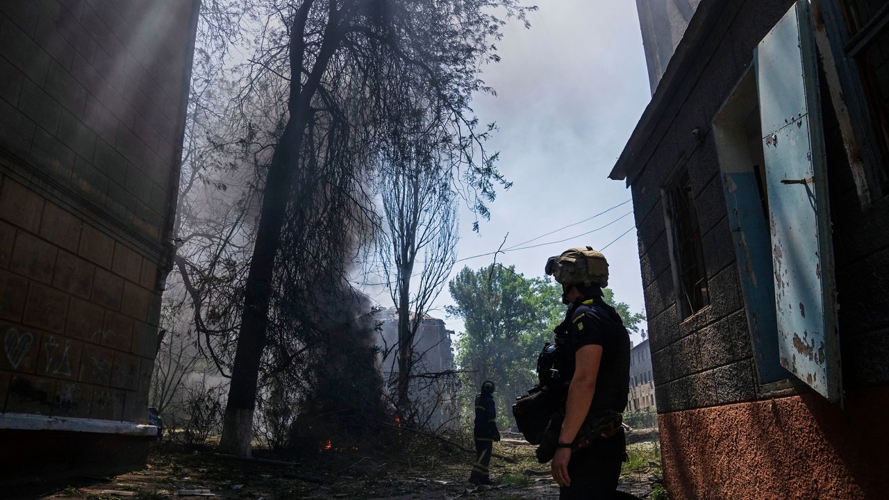 Ukrainian service men look at the aftermath of a strike on a residential area, in Kramatorsk, Donetsk region, eastern Ukraine, Thursday, July 7, 2022. (AP Photo/Nariman El-Mofty)