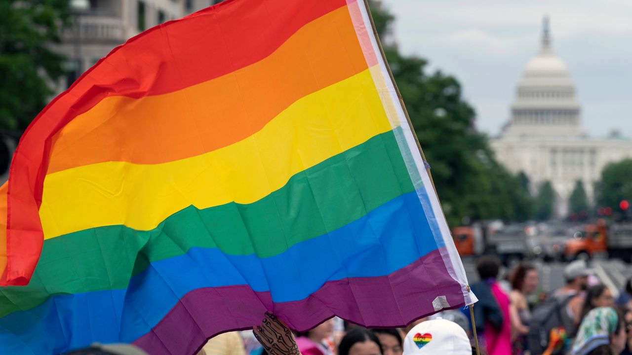 FILE - With the U.S. Capitol in the background, a person waves a rainbow flag as they participant in a rally in support of the LGBTQIA+ community at Freedom Plaza, Saturday, June 12, 2021, in Washington. (AP Photo/Jose Luis Magana, File)