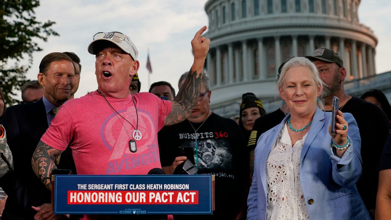 Activist John Feal, left, speaks as Sen. Kirsten Gillibrand, D-N.Y., films him at a news conference after the Senate passed a bill designed to help millions of veterans exposed to toxic substances during their military service, Tuesday, Aug. 2, 2022, on Capitol Hill in Washington. (AP Photo/Patrick Semansky)