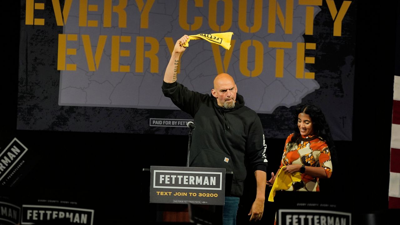 Pennsylvania Lt. Gov. John Fetterman, the Democratic nominee for the state's U.S. Senate seat, waves a towel after being introduced by wife Gisele Barreto Fetterman, right, during a rally in Erie, Pa., on Friday, Aug. 12, 2022. (AP Photo/Gene J. Puskar)