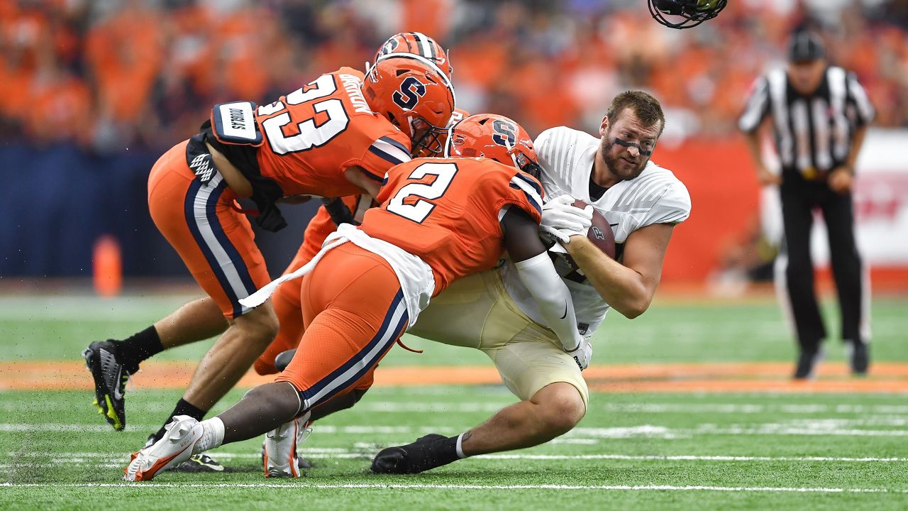 Purdue tight end Payne Durham, right, loses his helmet while being tackled by Syracuse linebacker Marlowe Wax (2) and defensive back Justin Barron (23) during the first half of an NCAA college football game in Syracuse, N.Y., Saturday, Sept. 17, 2022. (AP Photo/Adrian Kraus)