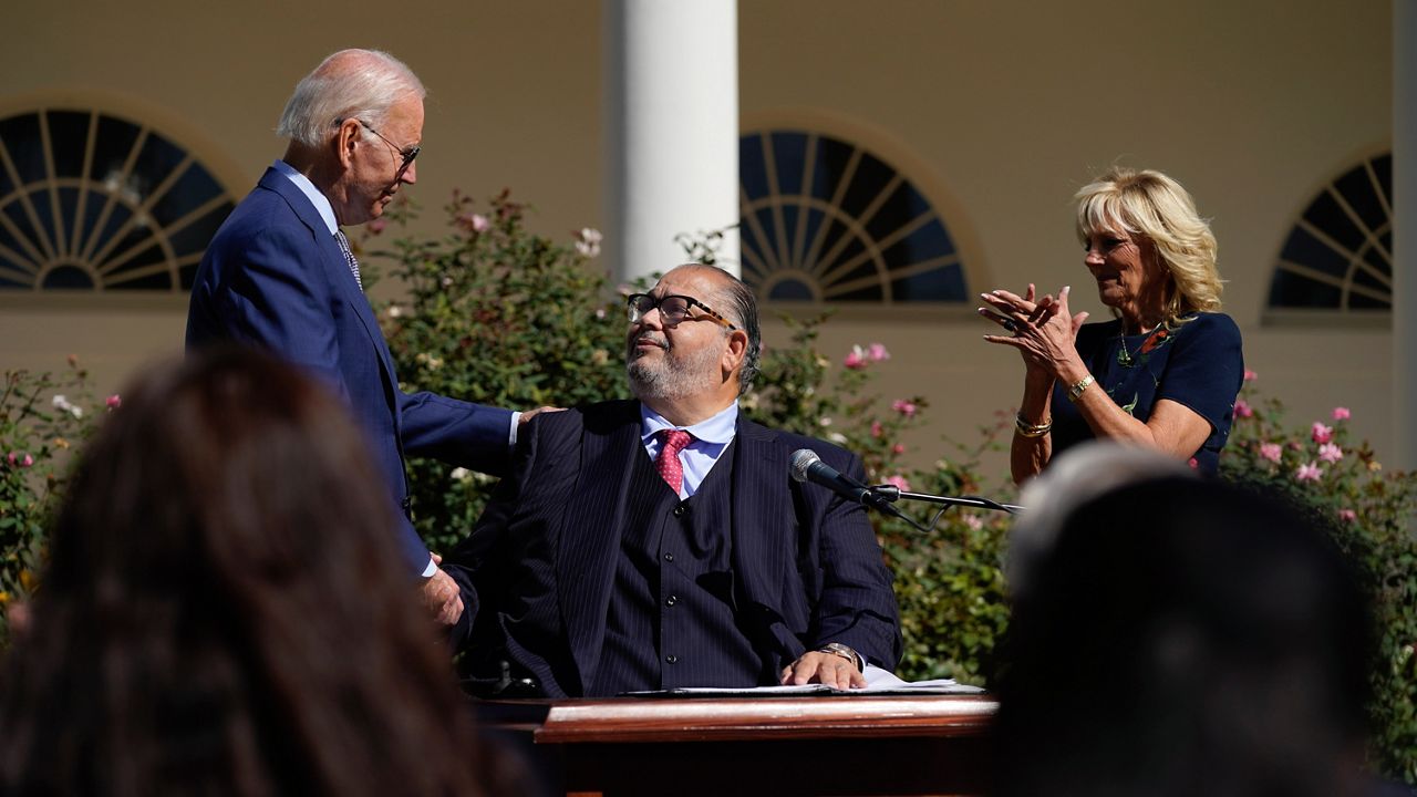 President Joe Biden shakes hands with Bowie, Md., Mayor Tim Adams as first lady Jill Biden applauds during a celebration of the Americans with Disabilities Act, and to mark Disability Pride Month, in the Rose Garden of the White House, Wednesday, Sept. 28, 2022, in Washington. (AP Photo/Evan Vucci)