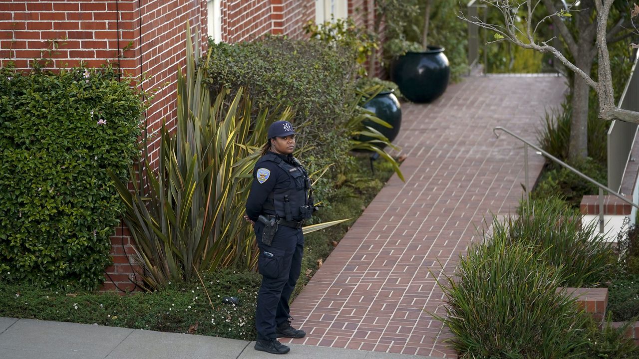 A police officer stands outside the home of House Speaker Nancy Pelosi and her husband Paul Pelosi in San Francisco, Friday, Oct. 28, 2022. Paul Pelosi, was attacked and severely beaten by an assailant with a hammer who broke into their San Francisco home early Friday, according to people familiar with the investigation. (AP Photo/Godofredo A. Vásquez)