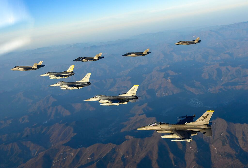 In this photo provided by South Korean Defense Ministry, four South Korean Air Force F-35 fighter jets, left top, and four US Air Force F-16 fighter jets fly over South Korea during a joint air drill in South Korea, Friday, Nov. 18, 2022. North Korea fired an intercontinental ballistic missile that landed near Japanese waters Friday in its second major weapons test this month that showed a potential ability to launch nuclear strikes on all of the U.S. mainland. (South Korean Defense Ministry via AP)