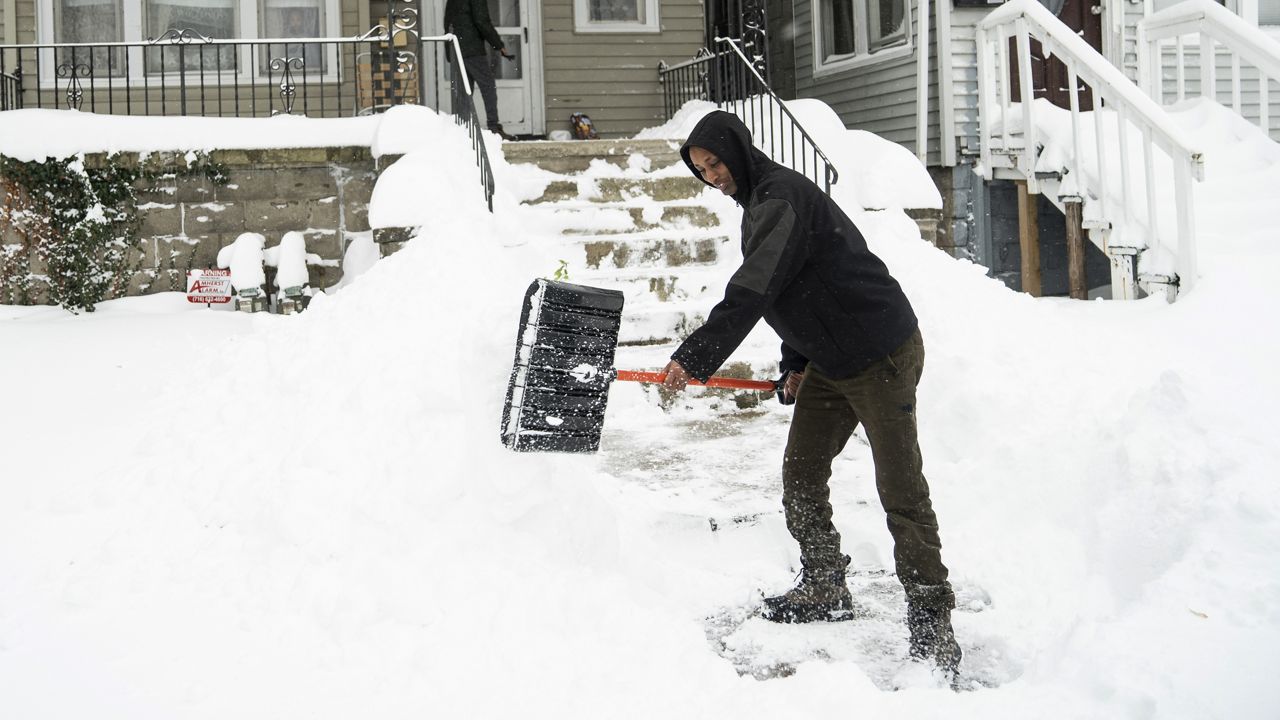 Ahmed Osman shovels his walk on the West Side, Saturday, Nov. 19, 2022 in Buffalo, N.Y. Residents of northern New York state are digging out from a dangerous lake-effect snowstorm that had dropped nearly 6 feet of snow in some areas and caused three deaths. The Buffalo metro area was hit hard, with some areas south of the city receiving more than 5 feet by early Saturday. (Libby March /The Buffalo News via AP)